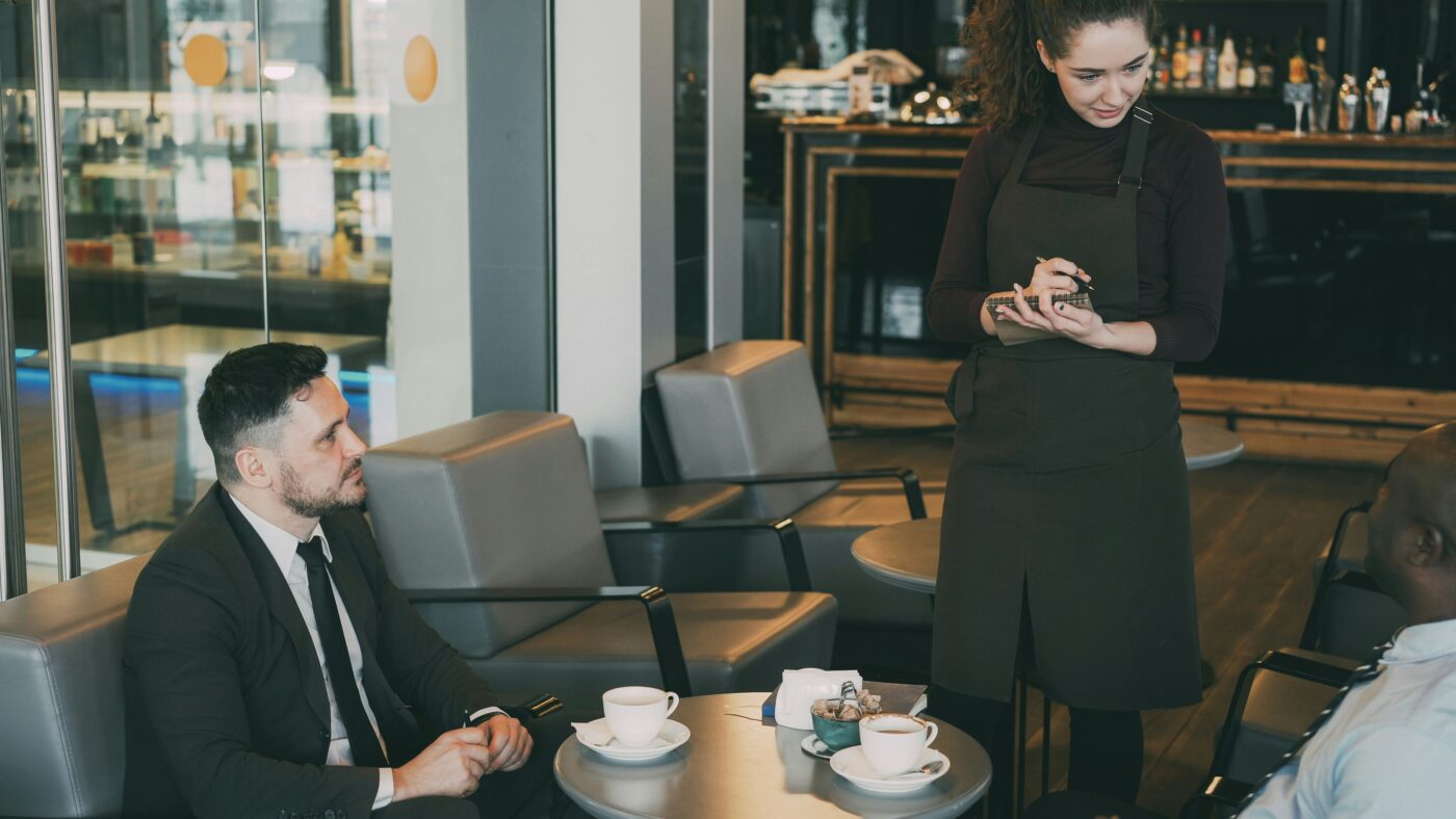 A hospitality business owner takes an order from a customer